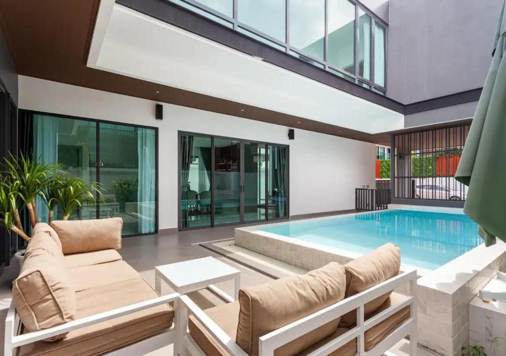 农布Astro Deluxe 4 Bedrooms Villa的一个带游泳池和房子的客厅
