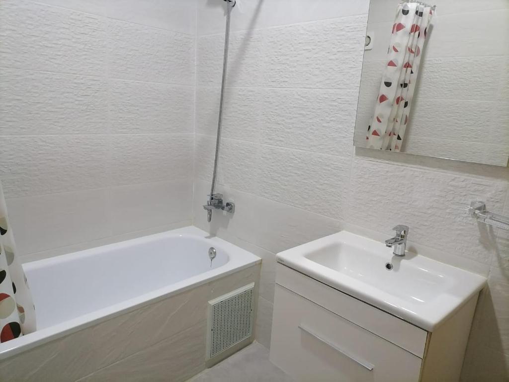 丹吉尔Apartment chakira family only的白色的浴室设有水槽、浴缸和镜子