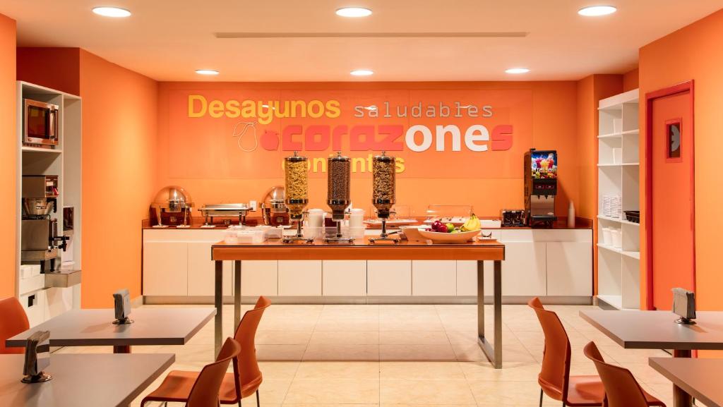 伊拉普阿托One Irapuato的餐厅拥有橙色的墙壁和桌椅
