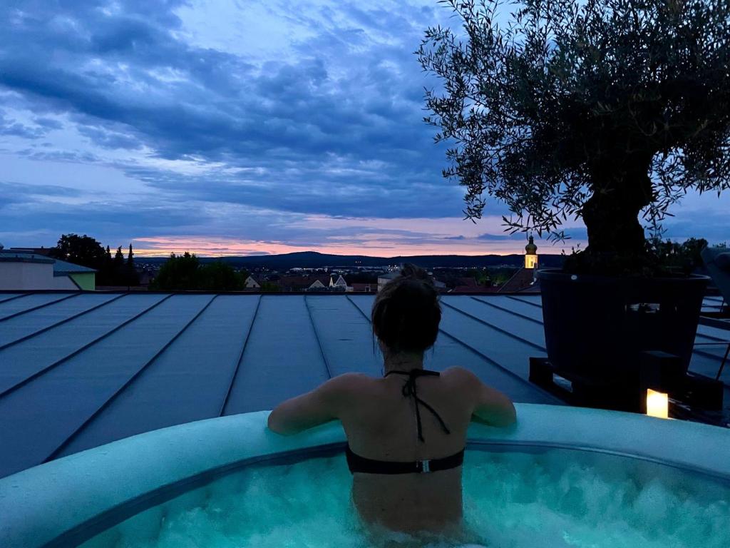 罗丁Luxus Loft über den Dächern von Roding的屋顶游泳池里的女人