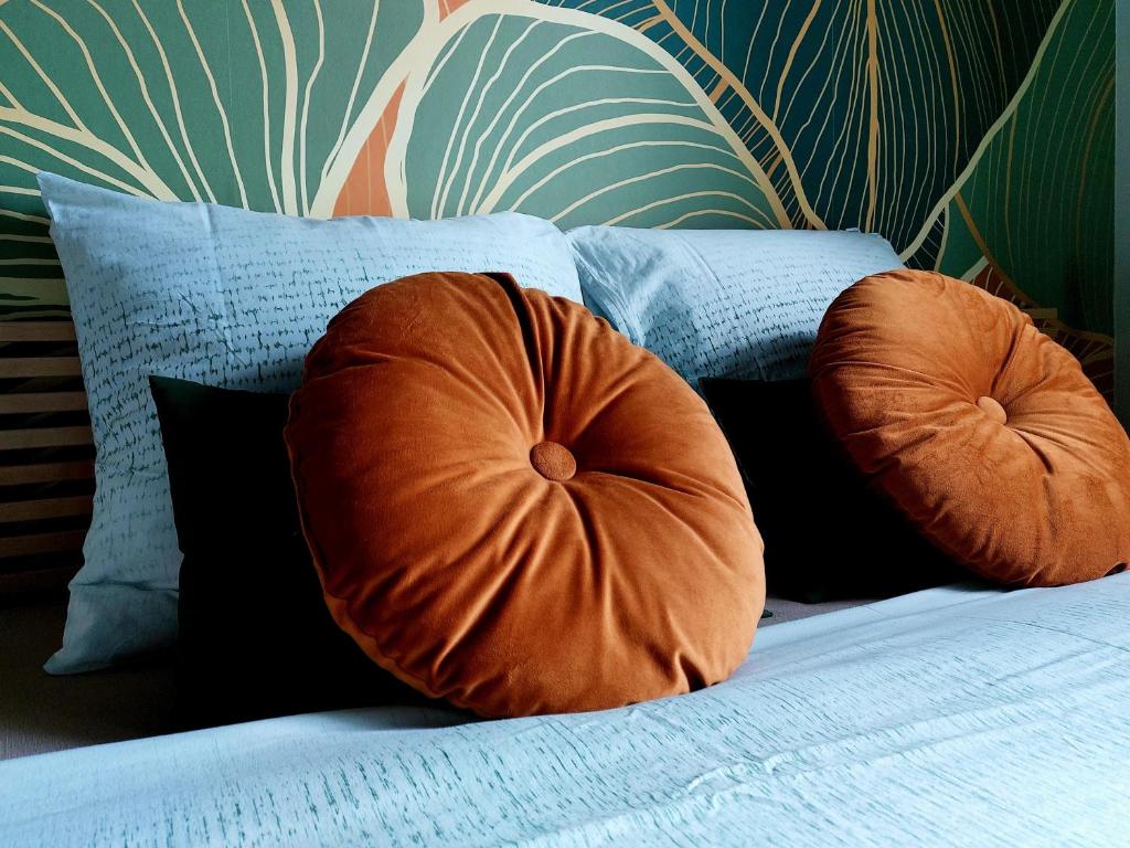 那慕尔Avou nozôtes的一张带两个橙色枕头的床