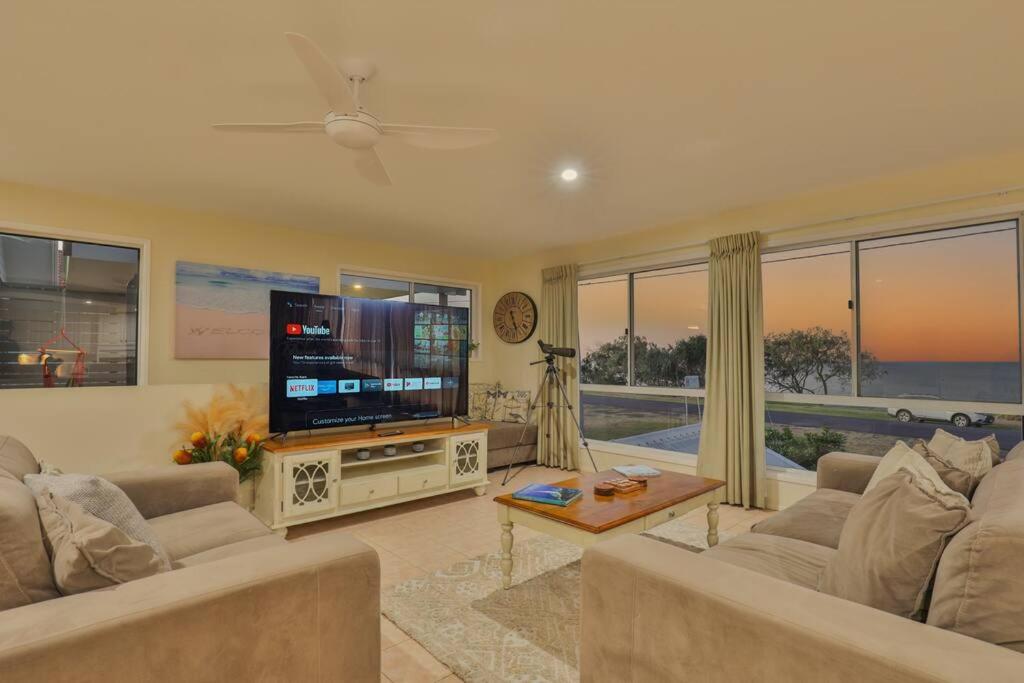 Burnett HeadsEdge of Oaks Beach的客厅配有平面电视和沙发。