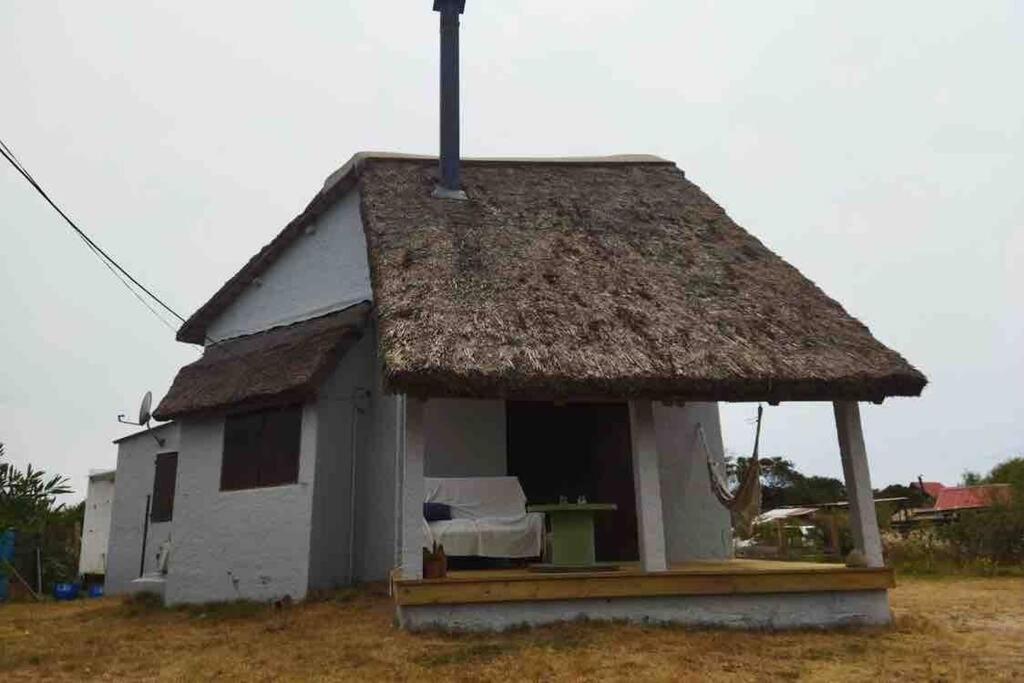 巴拉德瓦利扎斯Casa en Valizas a 250m del mar的茅草屋顶的小房子,带门廊