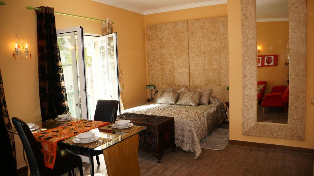 拉戈斯拉戈斯中心一室公寓的一间卧室配有一张床铺和一张桌子,还有一间用餐室