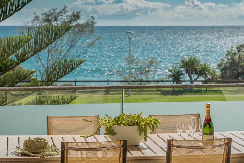 拜伦湾海滩套房酒店的一张桌子,配有一瓶葡萄酒,享有海景