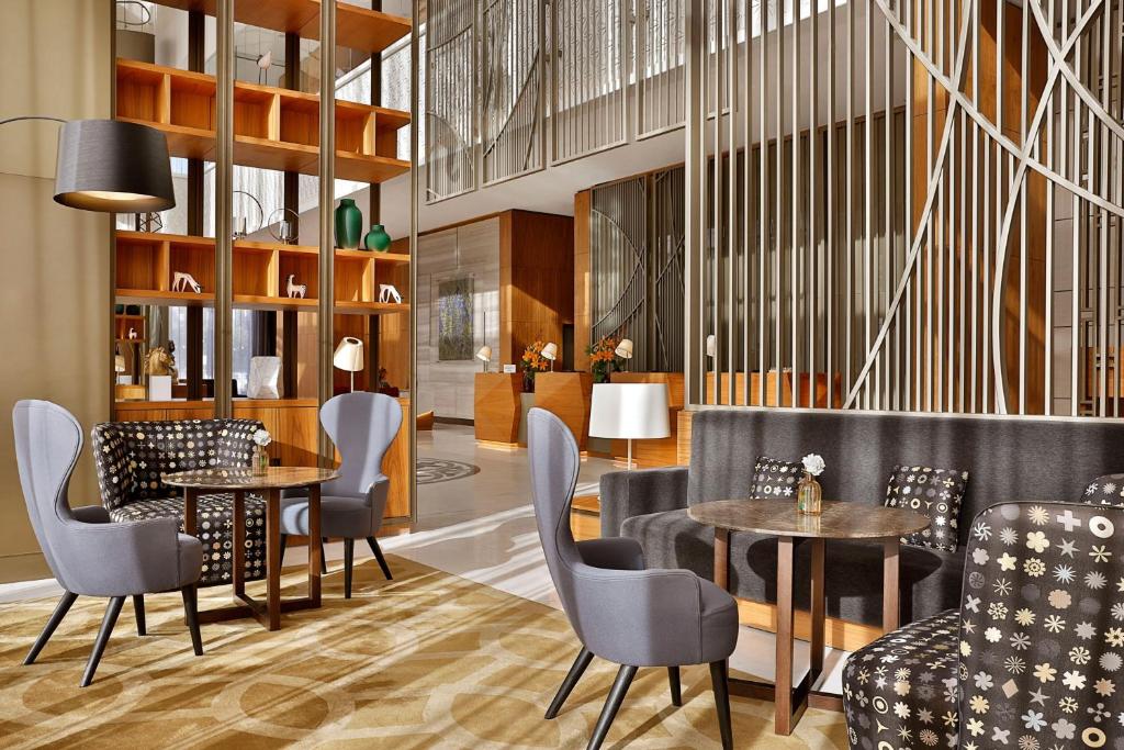 阿斯塔纳Sheraton Astana Hotel的一间在房间内配有桌椅的餐厅