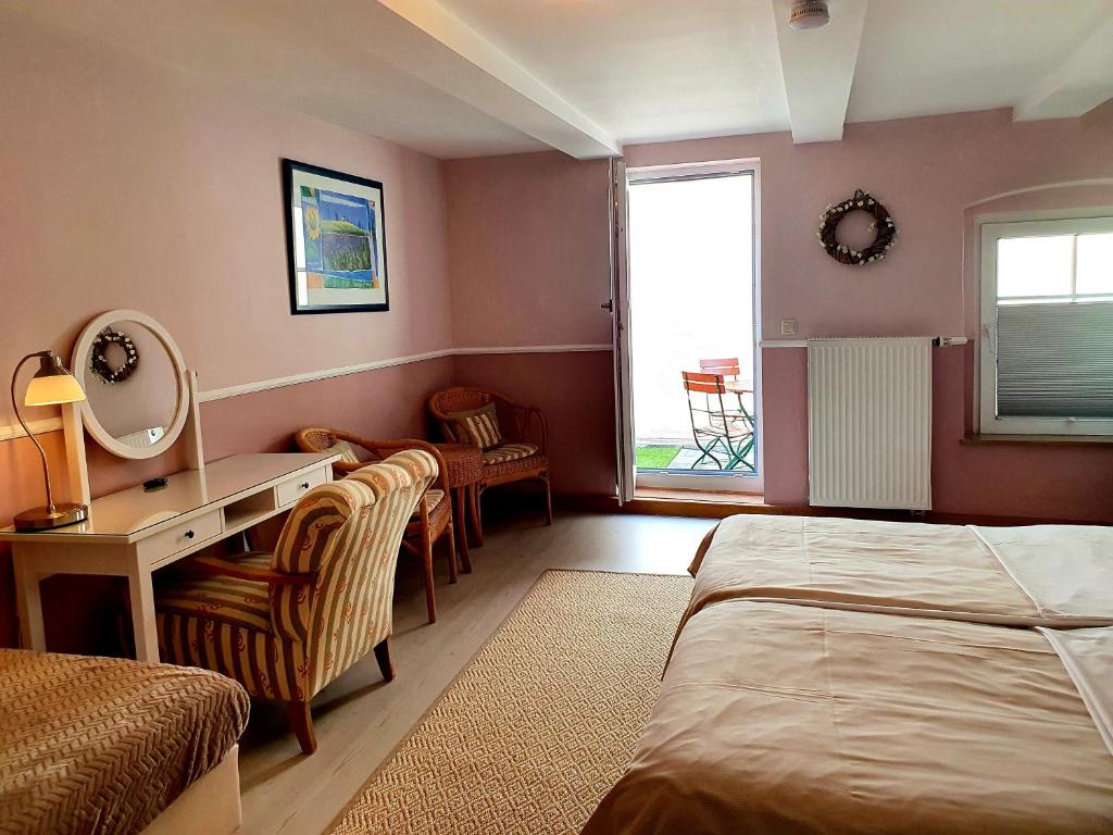 帕德博恩阿尔特恩基恩格尔穆勒酒店的一间卧室配有一张床和一张带镜子的书桌