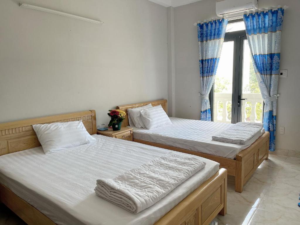 Cam LâmMoc homestay- Near Bai Dai Beach的带窗户的客房内的两张床