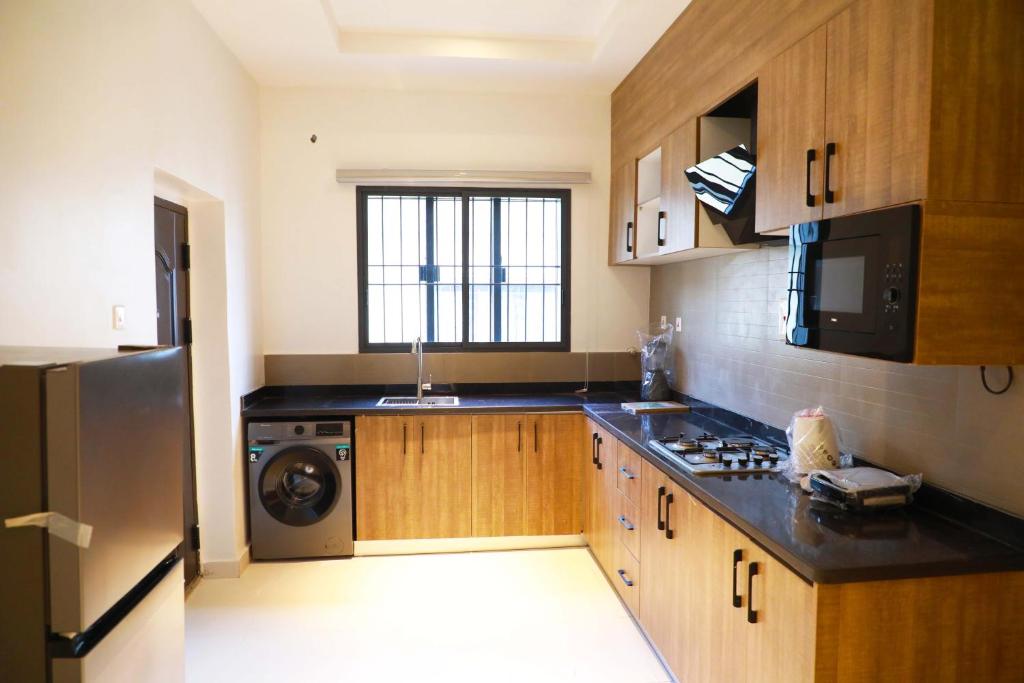 阿布贾Omah Apartments的厨房配有炉灶、水槽和冰箱。