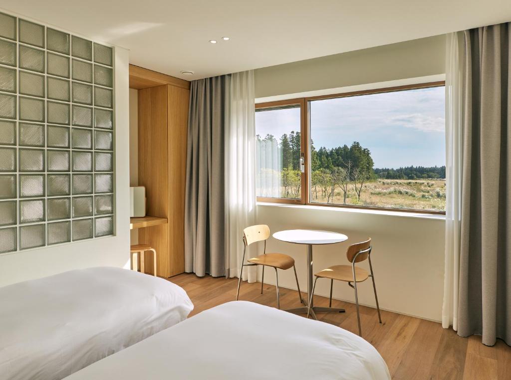 济州市Gonggan7的酒店客房设有床、桌子和窗户。