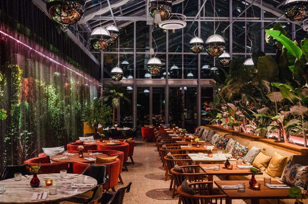 柏林sly Berlin的一间设有桌椅的餐厅,种植了植物