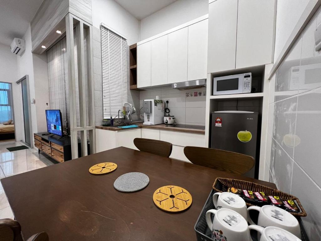 东贡岸ITCC Manhattan Suites by Blossom37的一间带桌子的厨房和一间带冰箱的厨房