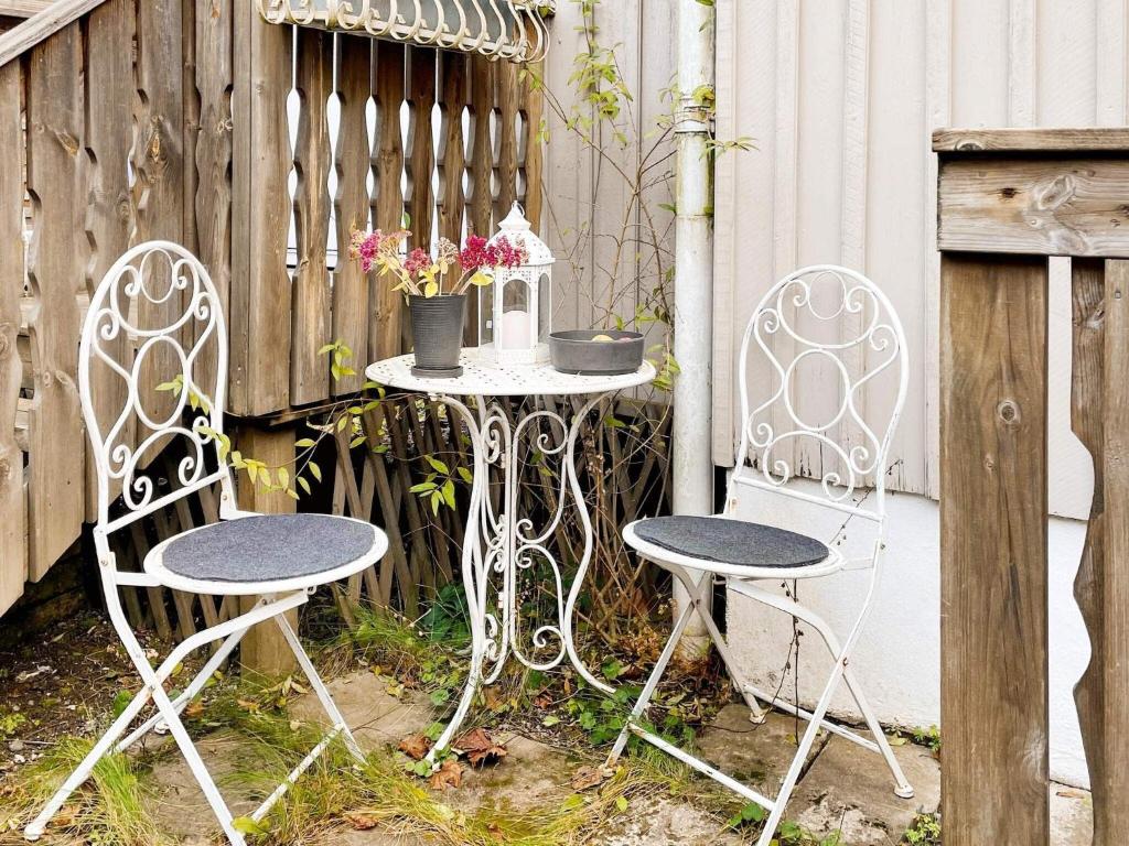 斯德哥尔摩Holiday home BROMMA II的围栏旁的两把椅子和一张桌子