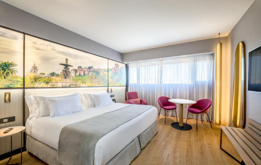 马拉加马拉加巴瑟罗酒店的酒店客房带一张床、一张桌子和椅子