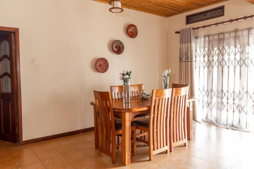 金贾Nilescape Residence的一间带木桌和椅子的用餐室