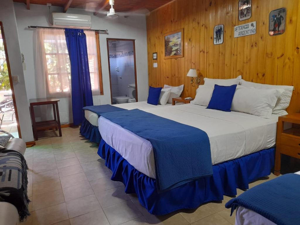 伊瓜苏港伊瓜苏港口酒店的一间卧室配有两张带蓝白色床单的床
