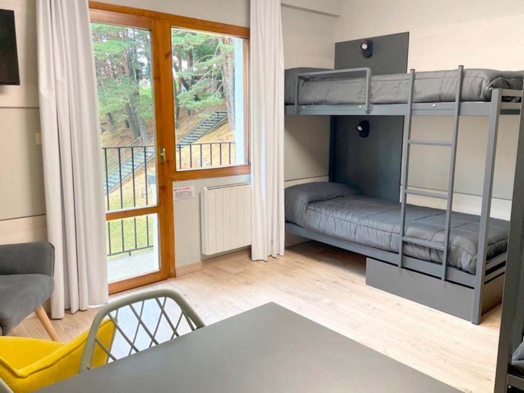 福米加尔Apartamentos Midi 3000的小房间设有双层床和桌子