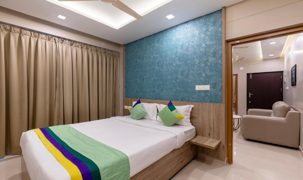 古鲁瓦尤尔Treebo Trend Sreepathi Prayag Apartments的一间卧室配有一张床和一个沙发