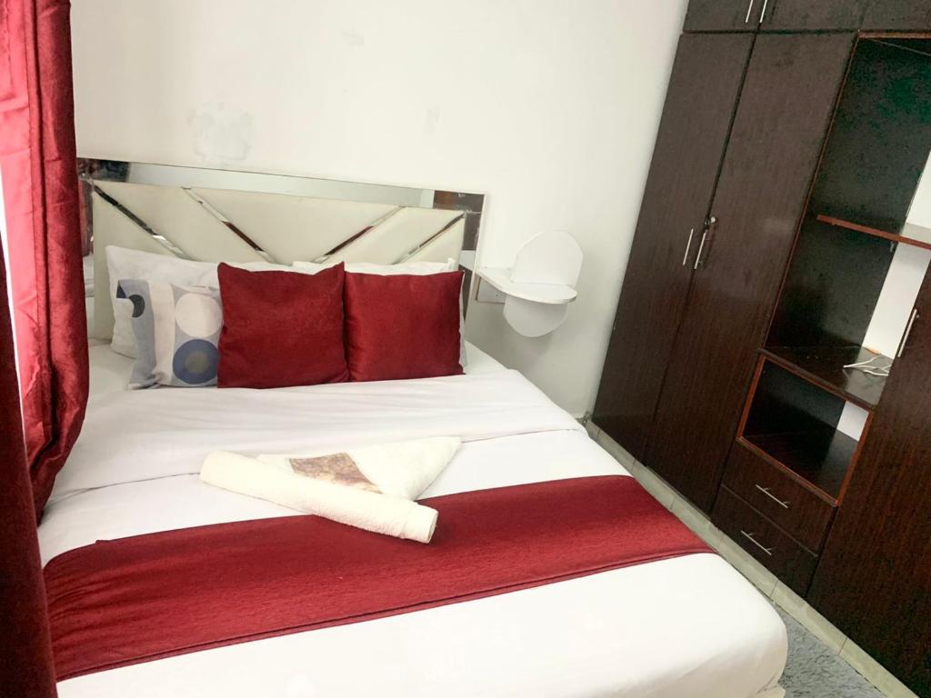 埃尔多雷特Rorot Spacious one bedroom in Kapsoya with free Wifi的一间卧室配有红色和白色枕头的床