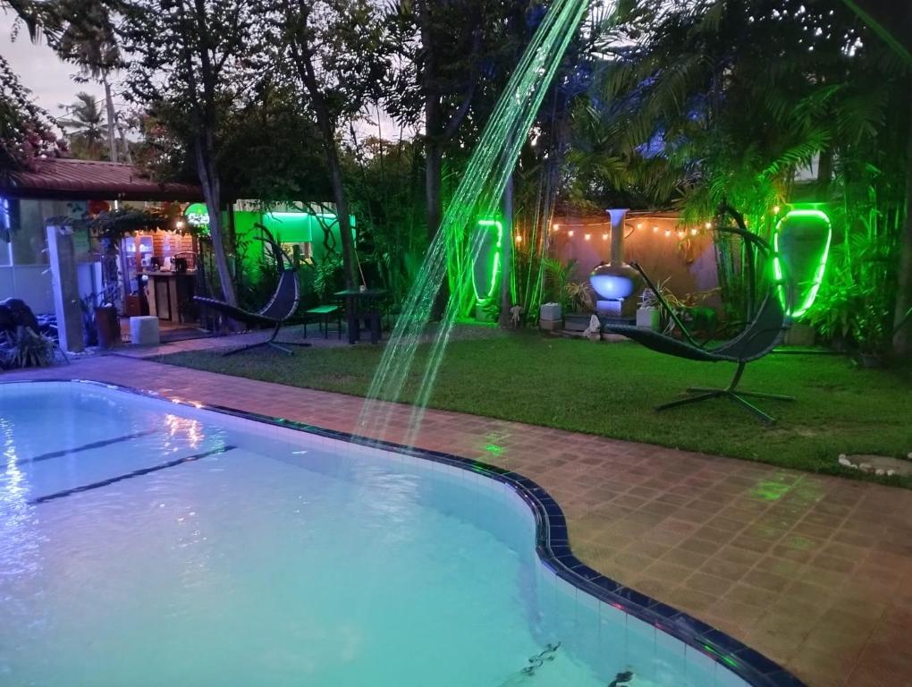 尼甘布棕榈别墅旅馆的后院的游泳池,在晚上有喷泉