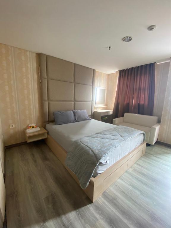 Pondokarenapartemen bintaro icon的一间卧室配有一张大床和一张沙发