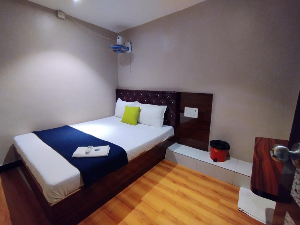 孟买Hotel Aspen - Near International Airport的小卧室配有白色的床和绿色枕头
