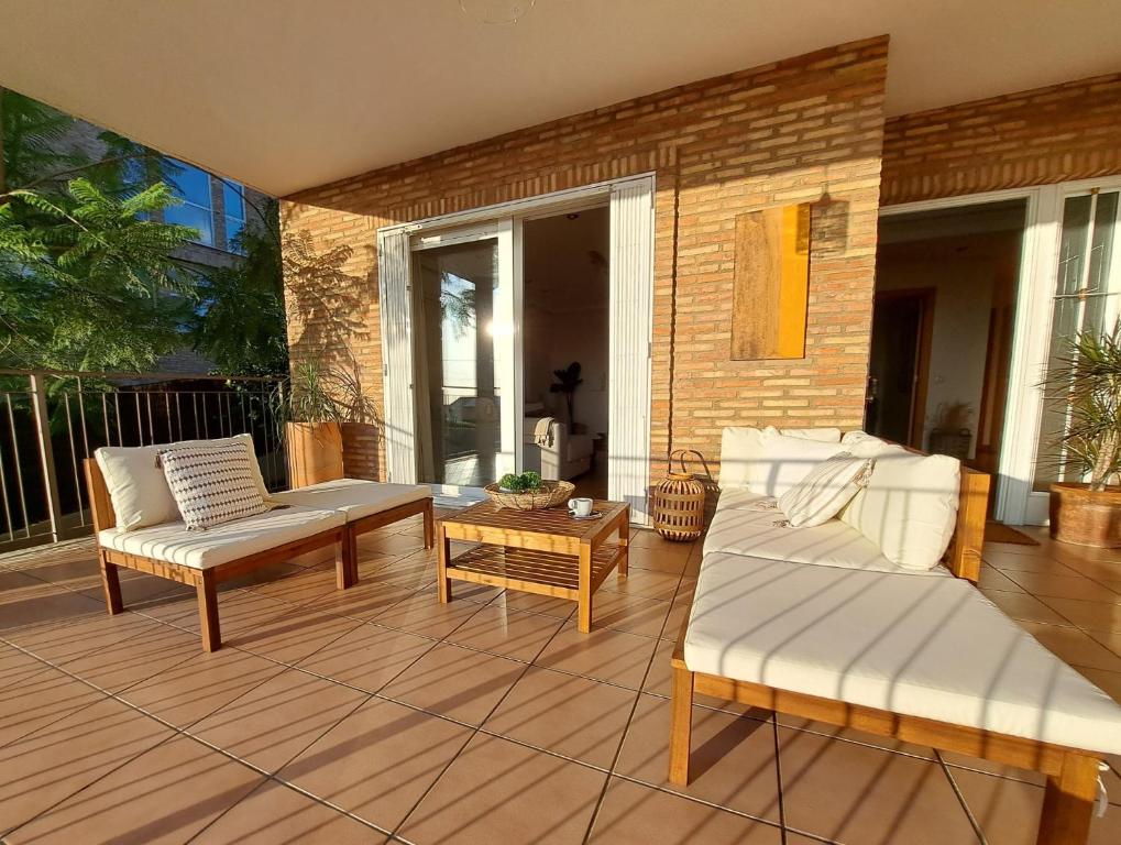 瓦伦西亚Casa en Valencia, cerca de golf, playas, moto Gp的天井配有2张沙发和1张咖啡桌