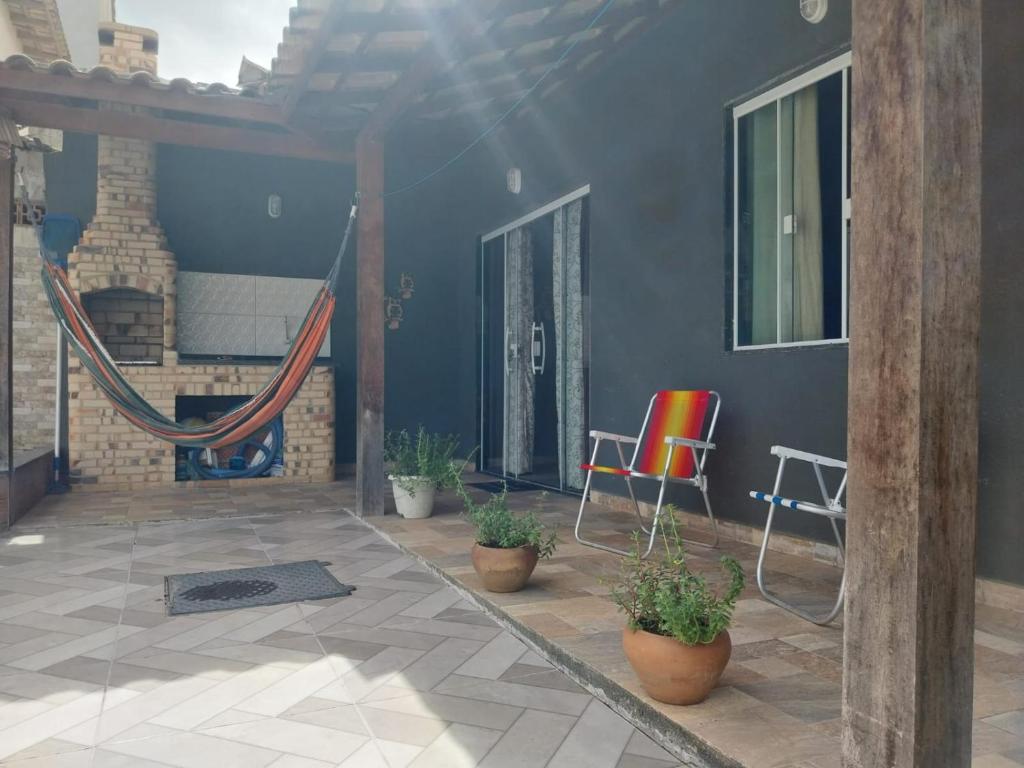 卡波布里奥Casa de praia em Unamar com piscina的房屋内带椅子和植物的庭院