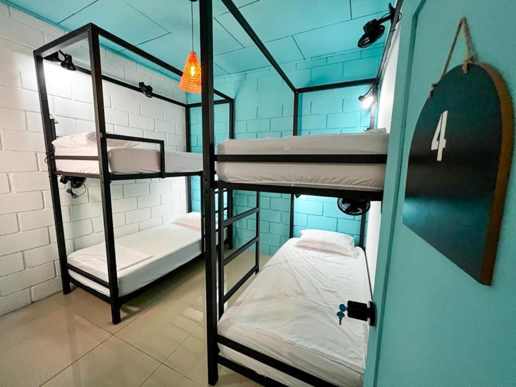 圣何塞Lolas Hostal, Habitacion Exclusiva para Mujeres, 2 camarotes, precio por cama的大楼内一间设有三张双层床的客房