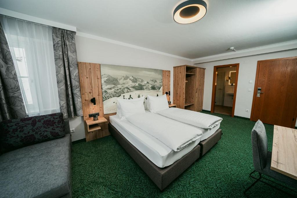 上陶恩阿帕特霍特尔山姆森公寓式酒店的卧室配有一张白色的大床和一张沙发。