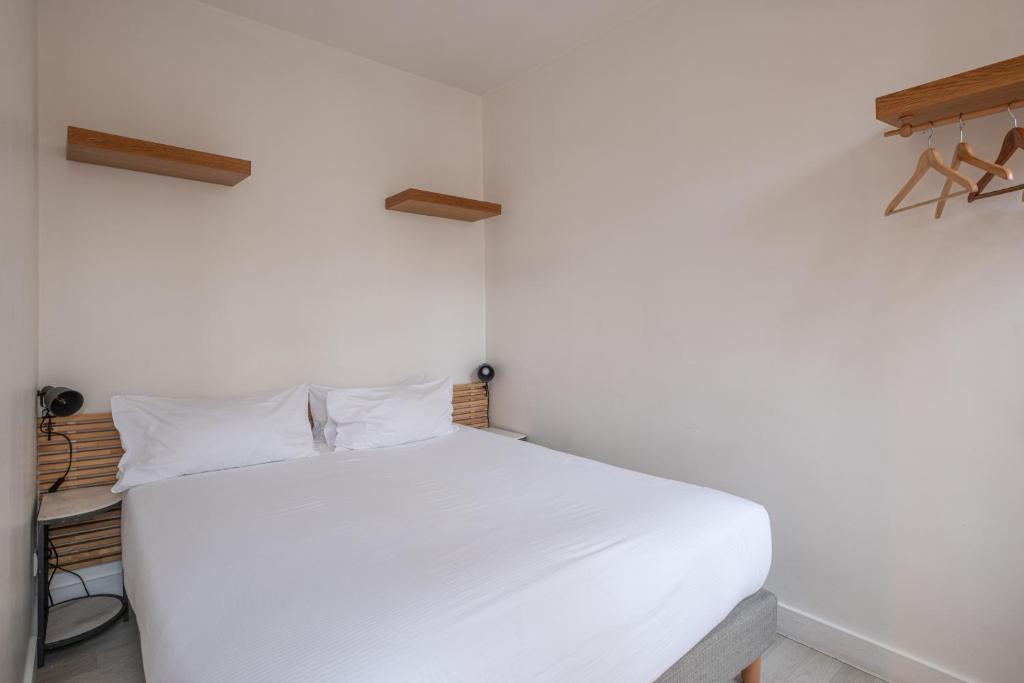 巴黎克里南柯特公寓酒店的卧室配有白色的床
