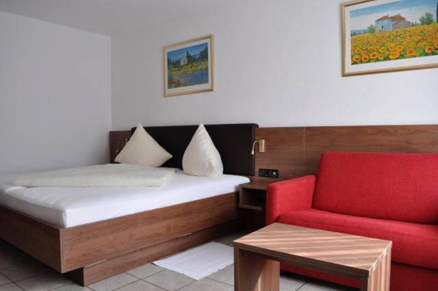 拉姆斯泰因-米森巴赫欧洲酒店的一间卧室配有一张床和一张红色椅子