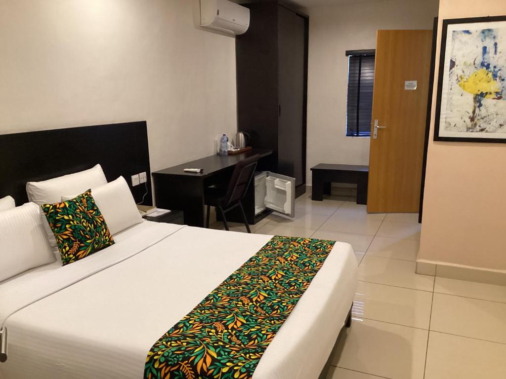 伊巴丹Adis Hotels Prime的一间卧室配有一张床和一张书桌