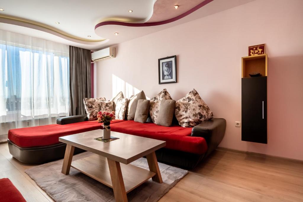 普罗夫迪夫罗西娜公寓的客厅配有红色的沙发和桌子