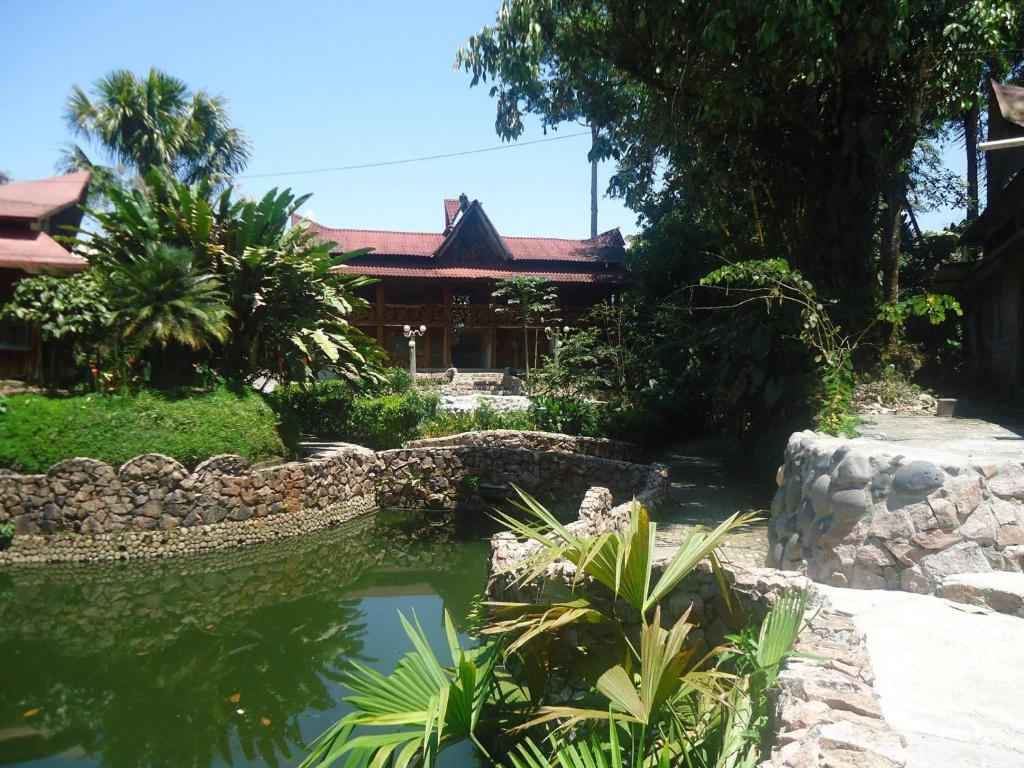 普约Hosteria Hachacaspi的一座花园,在一座建筑前设有一个池塘