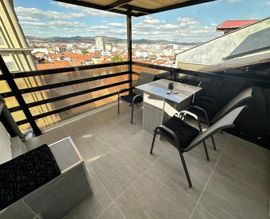 GnjilaneSA Apartment的大楼内的阳台配有桌椅