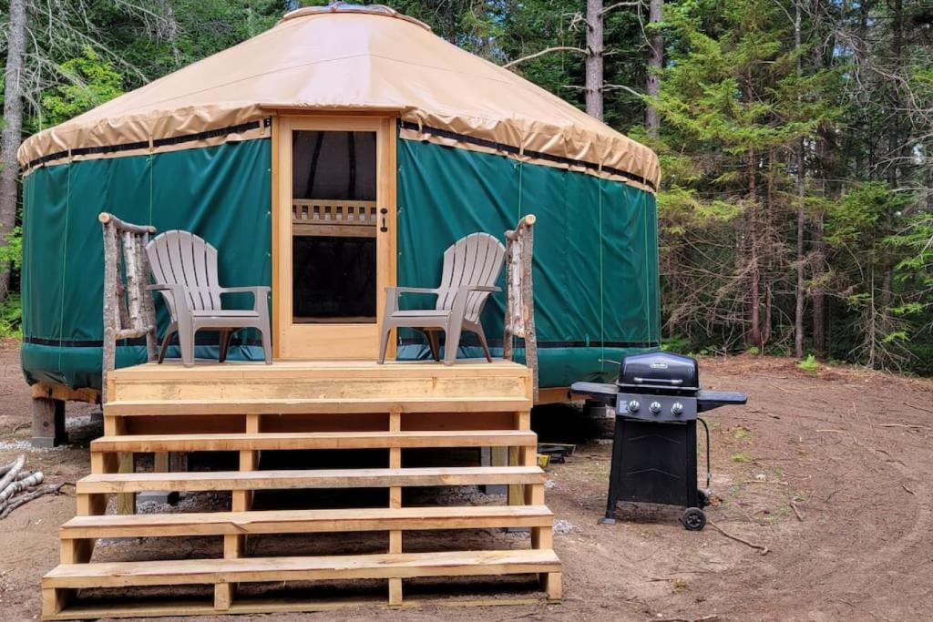 BrownfieldAllie Mae Yurt nestled in the woods的一个带2把椅子和烧烤架的蒙古包