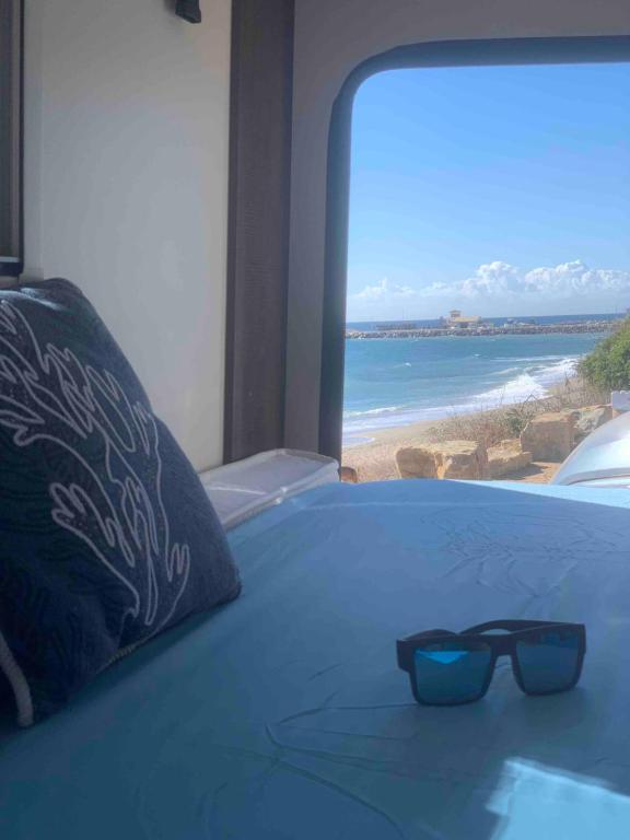 马贝拉Andalusian Lifestyle的坐在海滩上床上的太阳镜