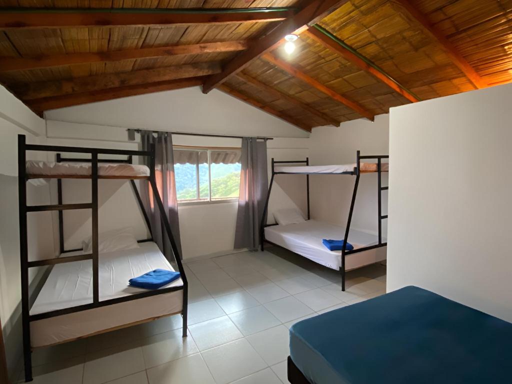 圣罗莎德卡瓦尔FINCA LA FORTALEZA的客房设有三张双层床和一扇窗户。