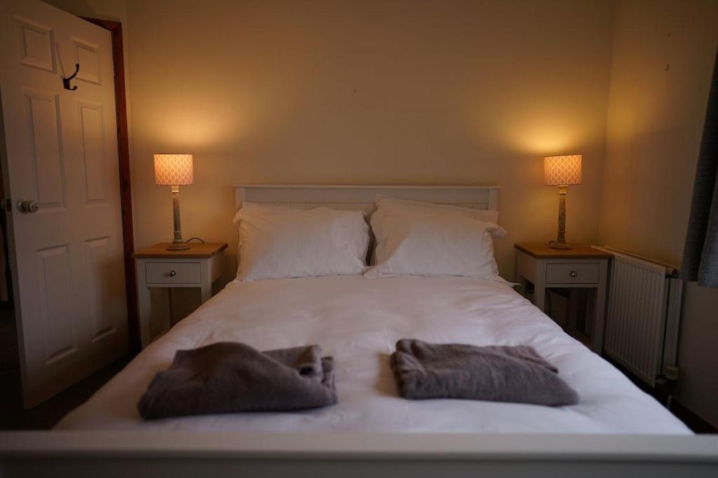 海景城Newell Cottage的一间卧室配有一张带两个枕头的床