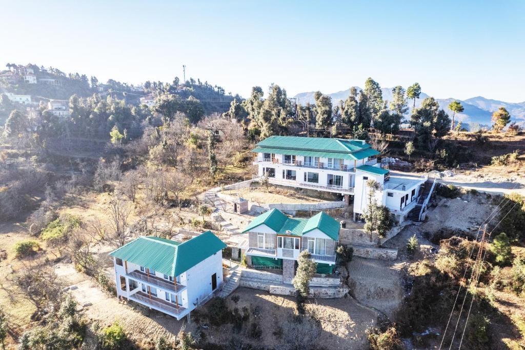 穆克缇斯瓦Shree Parijat Resort At Mukteshwar Hill Station with Himalayan View的享有绿色屋顶房屋的空中景致