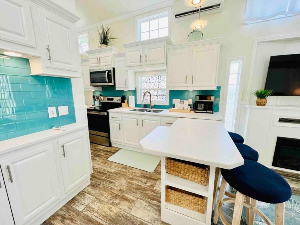 默特尔比奇Vacation Cottage North Myrtle Beach 65的厨房配有白色橱柜和蓝色色调