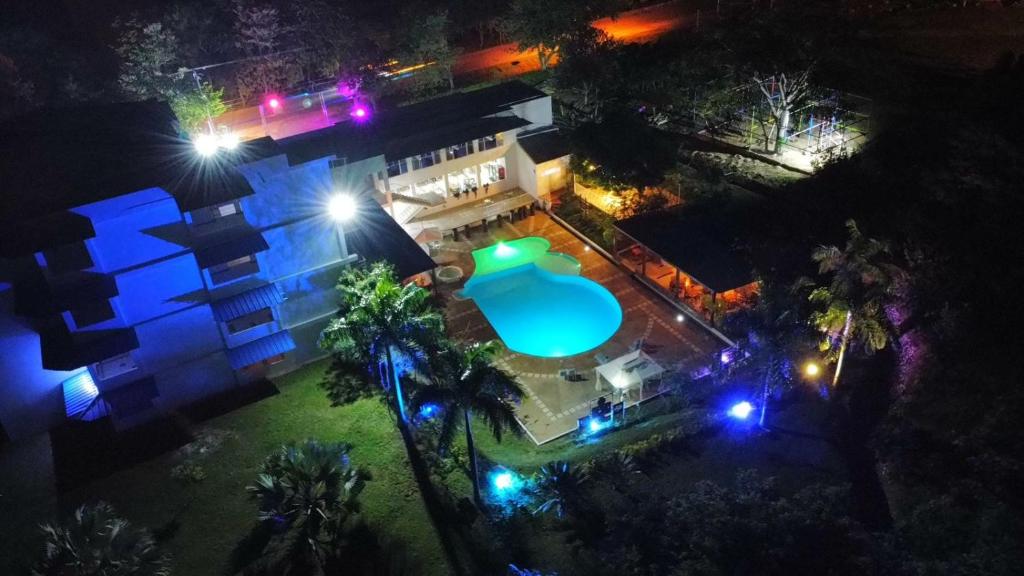 Paz de AriporoHOTEL EXBINT RESORT的享有房子顶部的景色,晚上设有游泳池