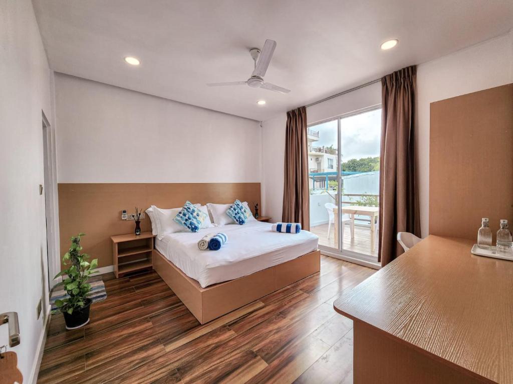 MahibadhooRaalhu Fonu Maldives的一间卧室配有一张带蓝色枕头的床。