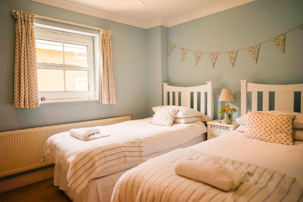 本布里奇Solent Landing的带窗户的客房内设有两张单人床。