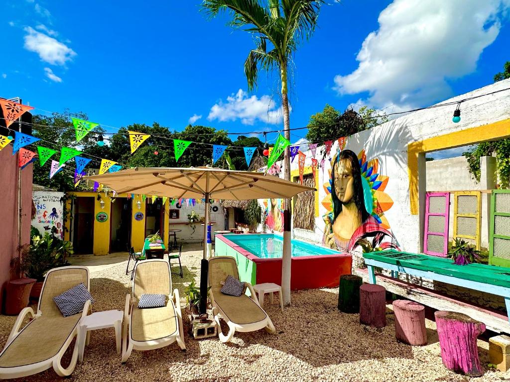 巴利亚多利德Hostal Guacamayas的桌椅、遮阳伞和游泳池