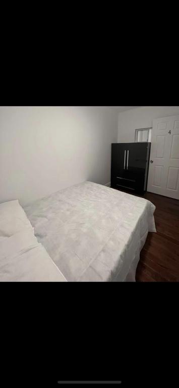 蒙特利尔Self-service small breakfast private Room 1的卧室配有白色的床和黑色橱柜。