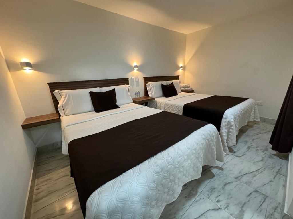 普埃布拉Hotel Royal Puebla的一间酒店客房,房间内设有两张床