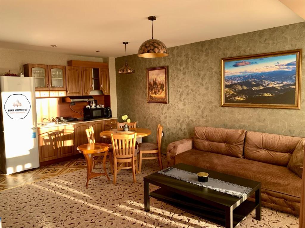 潘波洛沃Deluxe Apartment 33 Mountain Lodge Pamporovo的带沙发和桌子的客厅以及厨房。