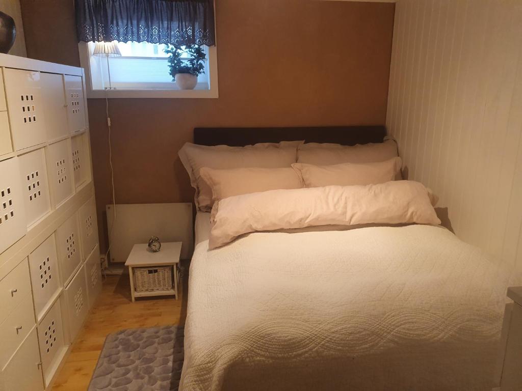 波多Koselig rom med stue i Bodø sentrum的一张铺有白色床单的床和一个窗户